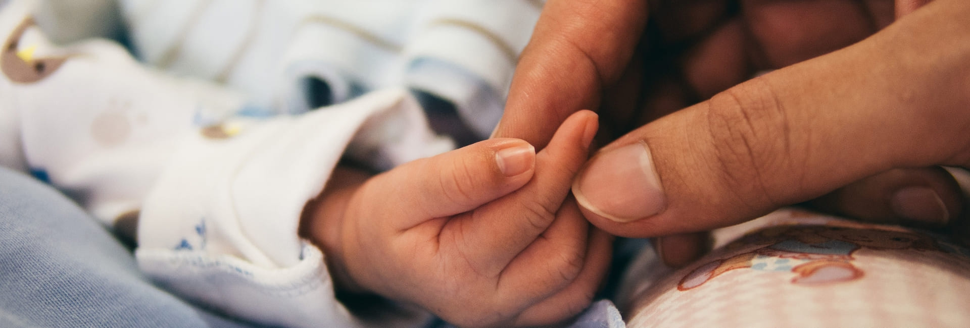 photo de papa et bébé à la naissance qui se tiennent la main