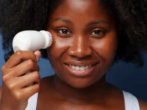 Une femme qui se lave le visage avec une brosse nettoyante