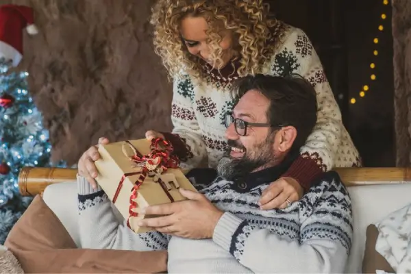 Une femme qui offre un cadeau à son mari