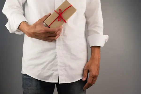 Un homme aveugle avec un cadeau à la main