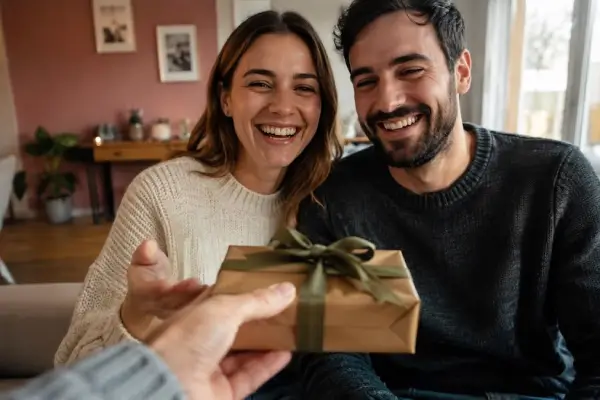 Une personne offre un cadeau à un couple